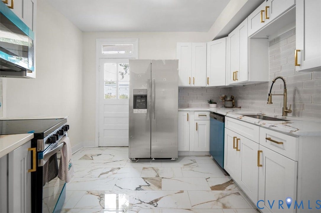 3510 Hanover Avenue, Museum District, Richmond, VA 23221 Kitchen featuring white cabinetry, gold-tone hardware, a stainless steel refrigerator, white countertops with veining, and a subway tile backsplash
