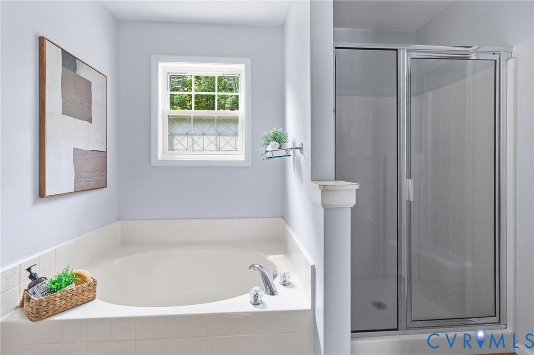 3173 Poplar View Place, Ashley Forest, Chester, VA 23831 Built-in soaking tub with tile surround, framed window, and clear glass shower enclosure