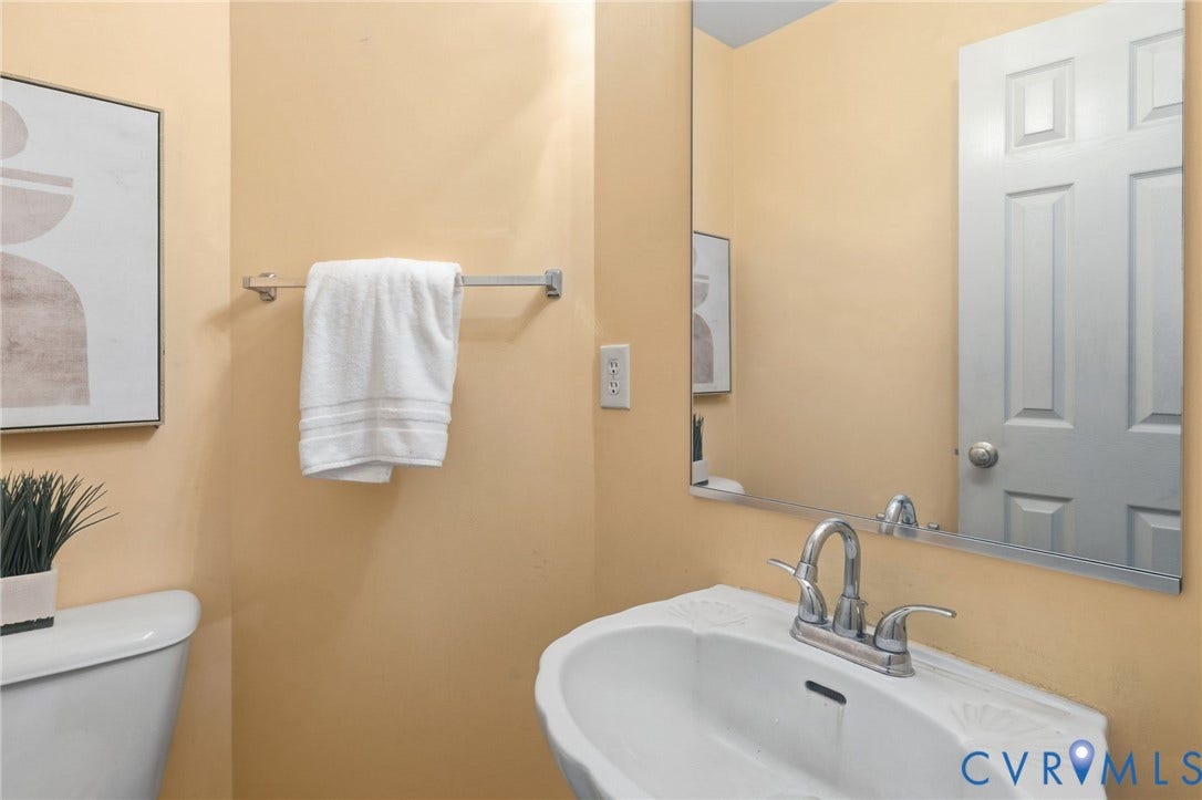 3173 Poplar View Place, Ashley Forest, Chester, VA 23831 Pedestal sink with chrome-finish faucet, wall-mounted mirror, and paneled door