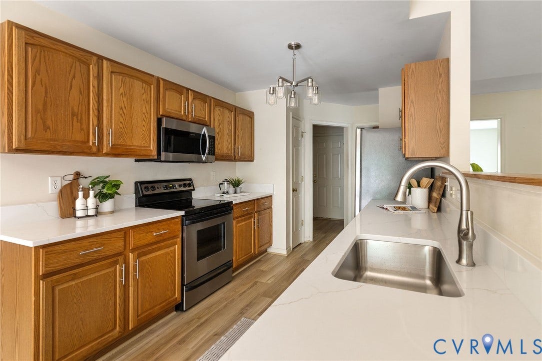 3173 Poplar View Place, Ashley Forest, Chester, VA 23831 Kitchen featuring wood-finish cabinetry, stainless steel appliances, white countertops, a stainless steel sink, and wood-finish flooring
