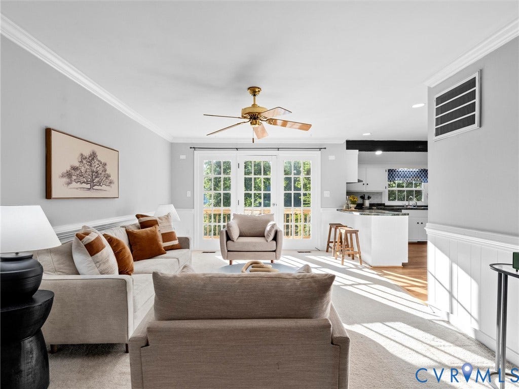 Crown molding, ceiling fan, carpet flooring, French doors, and a kitchen island with seating