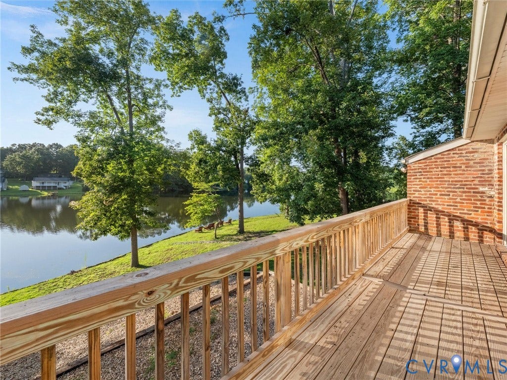 Spacious wood-finish deck with a wood railing and red brick exterior
