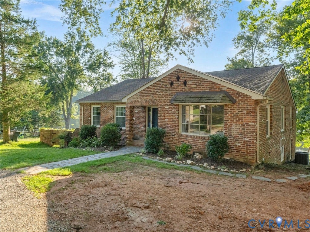 Brick exterior with multiple window styles, including a bay window with a shingled awning