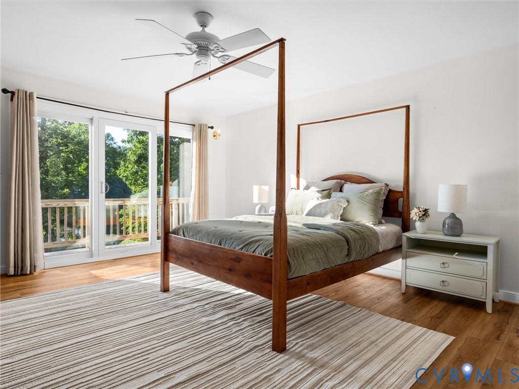 Hardwood-style flooring, white walls, ceiling fan, sliding glass door, and an exterior wood deck