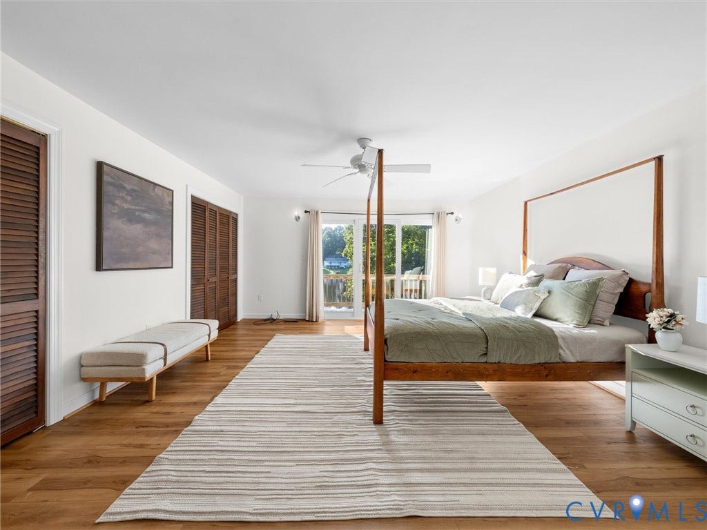 Wood-finish flooring, white walls, and louvered closet doors