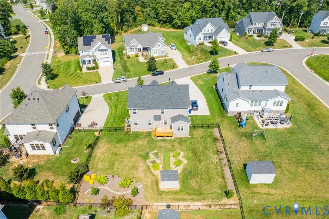 Aerial perspective showcasing a residential area with multiple homes, paved streets, and green landscaping