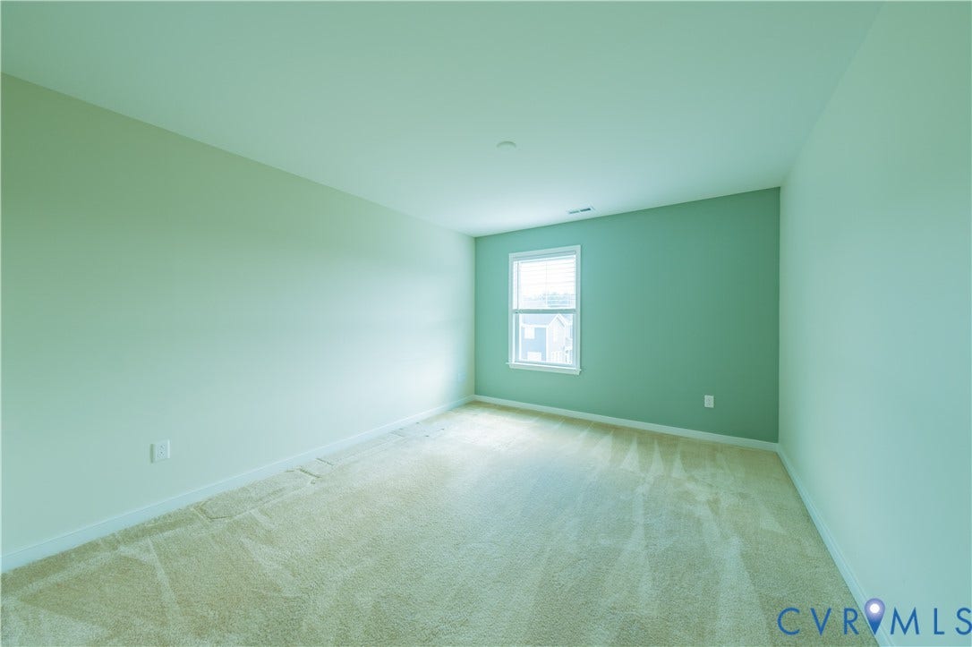 Expansive room featuring carpet flooring, painted walls, and a window with white trim