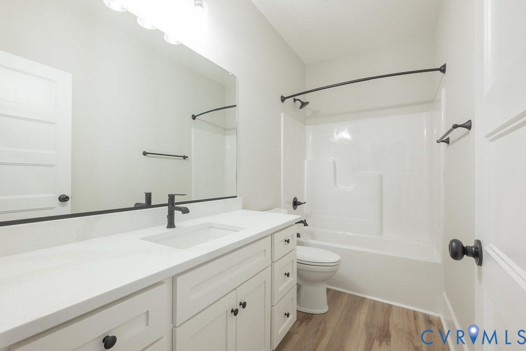 Lot 1A Tabscott Road, Columbia, VA 23038 Bathroom featuring a white vanity with an integrated sink, matte black fixtures, a full-width mirror, and a white tub/shower combination