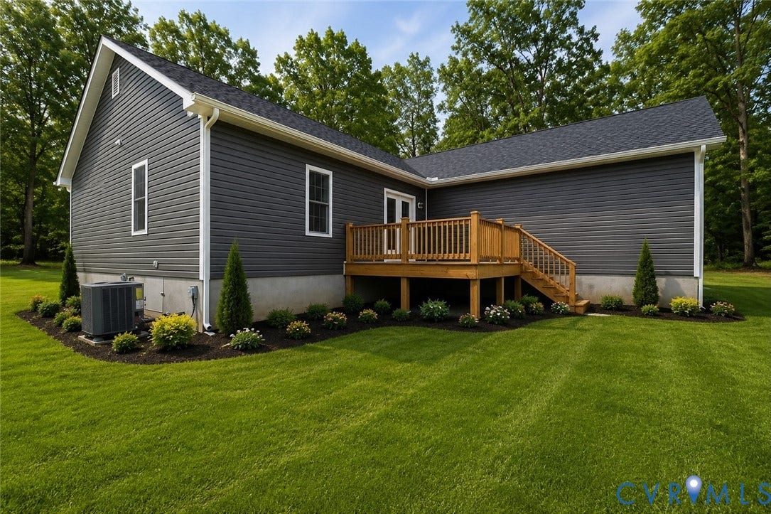 Lot 1A Tabscott Road, Columbia, VA 23038 Dark gray horizontal siding with white trim, a wood-finish deck with stairs, a dark asphalt shingle roof, and a perimeter of landscaping