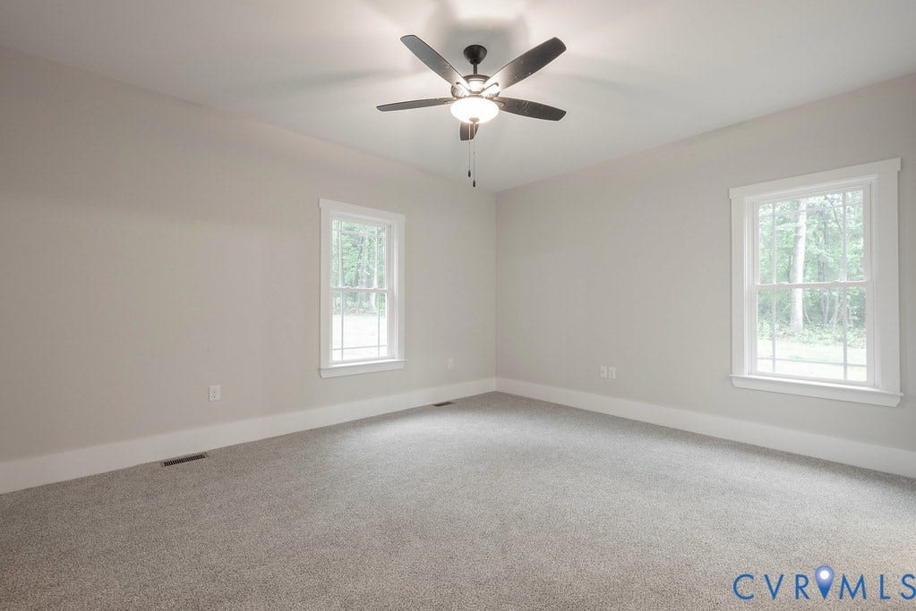Lot 1A Tabscott Road, Columbia, VA 23038 Spacious room featuring neutral carpeting, light gray walls, two double-hung windows with white trim, a ceiling fan with integrated lighting, and white baseboards