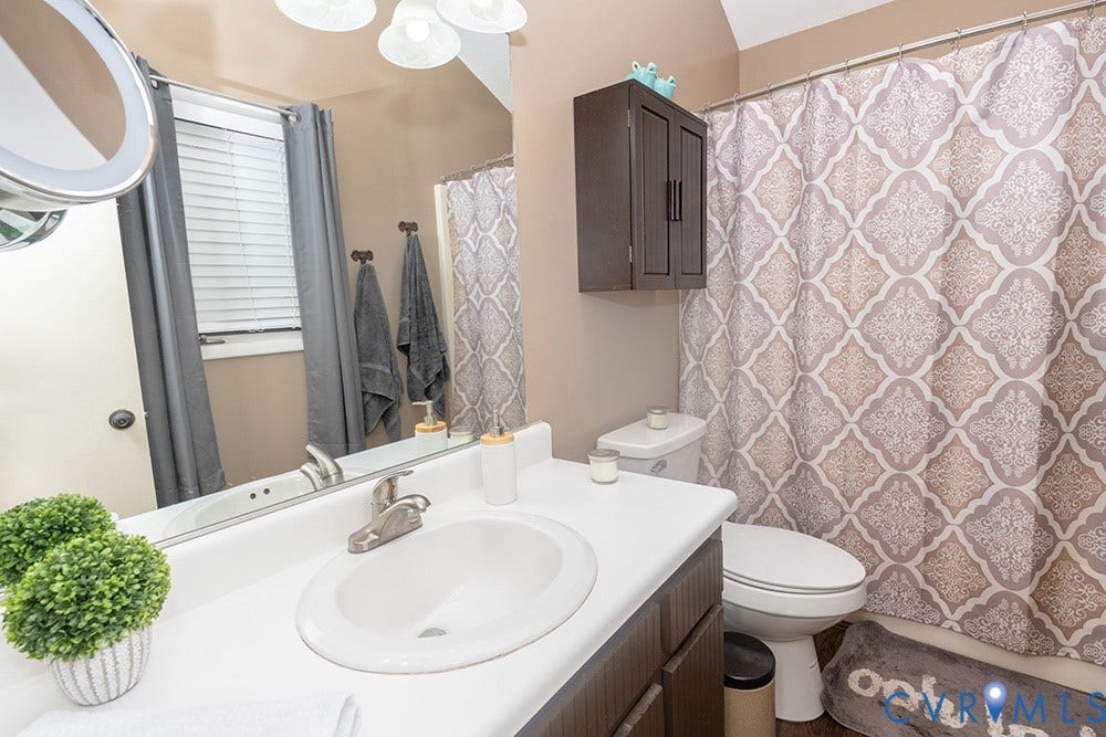 2209 Aspen Place, Henrico, VA 23233 White countertop with integrated sink, dark wood-finish vanity, wall-mounted storage cabinet, and a functional toilet