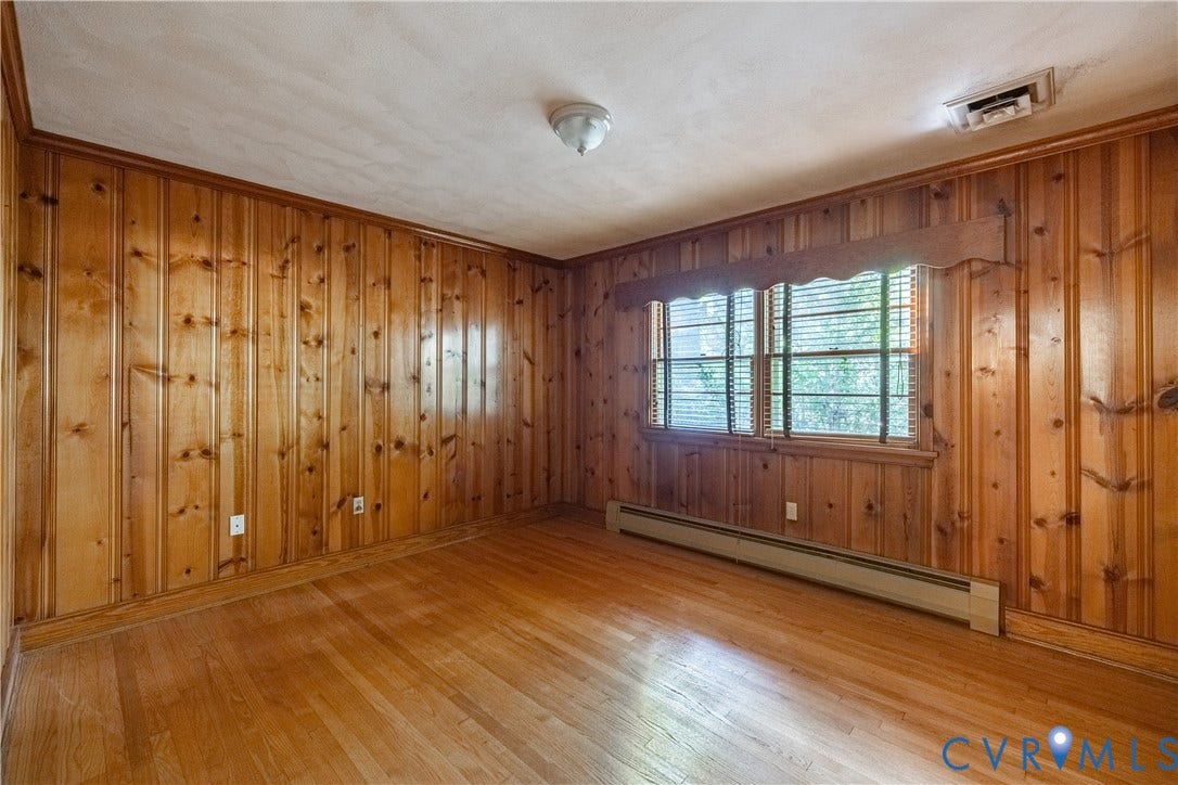 4532 Arrowhead Road, Statford Hills / Oxford, Richmond, VA 23235 Wood-paneled walls, wood-finish flooring, and a large window with horizontal blinds