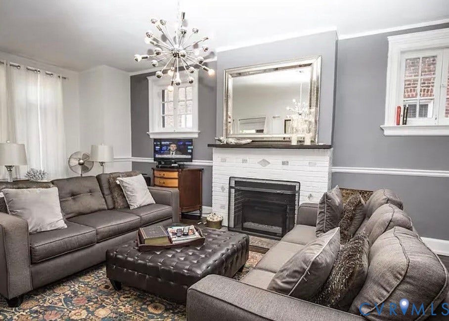710 N Arthur Ashe Boulevard, Historic Fan District, Richmond, VA 23220 White brick fireplace with dark hearth, crown molding, and a prominent chandelier