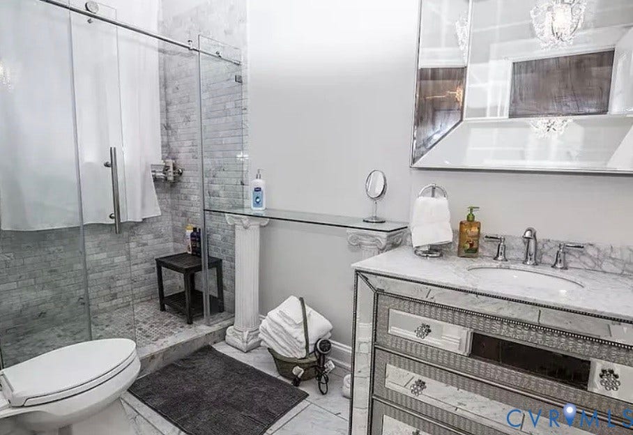710 N Arthur Ashe Boulevard, Historic Fan District, Richmond, VA 23220 Glass-enclosed shower with stone tile surround, mirror-paneled vanity with integrated sink, stone countertop, and custom decorative mirror