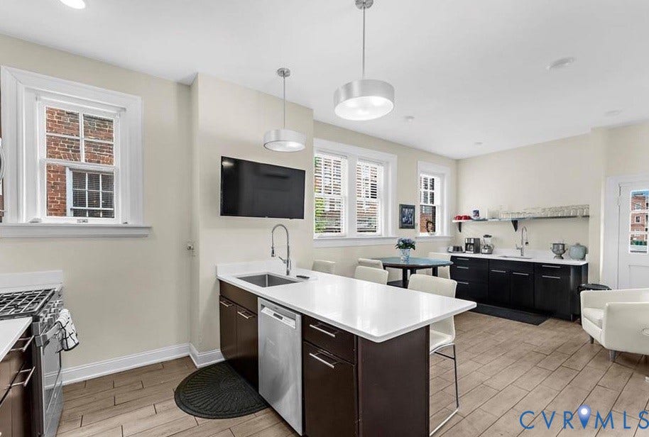 710 N Arthur Ashe Boulevard, Historic Fan District, Richmond, VA 23220 Spacious kitchen featuring an expansive island with seating, stainless steel appliances, wood-finish flooring, and pendant lighting