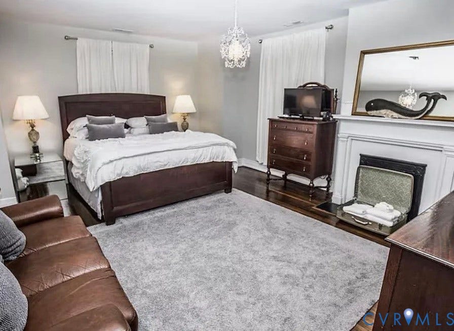 710 N Arthur Ashe Boulevard, Historic Fan District, Richmond, VA 23220 Hardwood flooring, decorative fireplace, chandelier lighting, wall-mounted mirror, and white window treatments