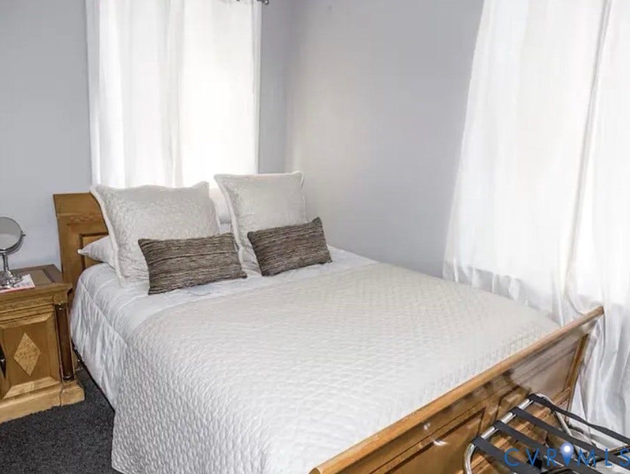 710 N Arthur Ashe Boulevard, Historic Fan District, Richmond, VA 23220 Light gray wall finish with white window treatments, dark gray carpet, and wood-finish bed frame