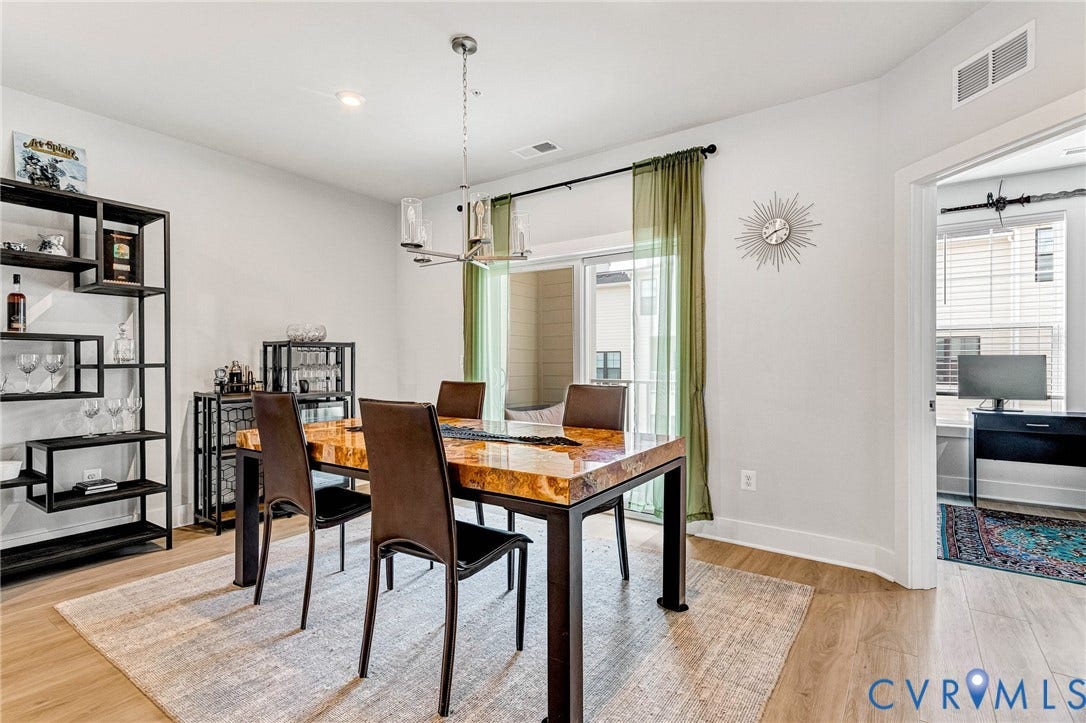528 Greybull Walk, #B, Glen Allen, VA 23233 Wood-finish flooring, recessed lighting, and a modern chandelier illuminate this bright space with access to an outdoor balcony