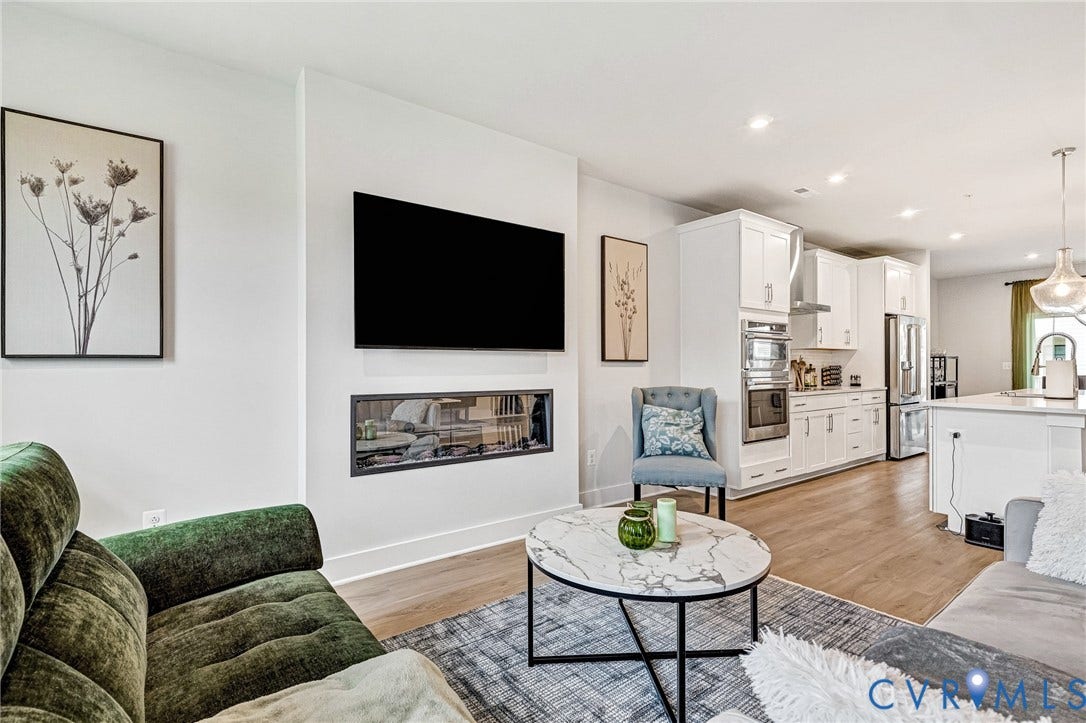 528 Greybull Walk, #B, Glen Allen, VA 23233 Open-concept living area featuring wood-finish flooring, a linear fireplace, recessed lighting, and a white kitchen with stainless steel appliances