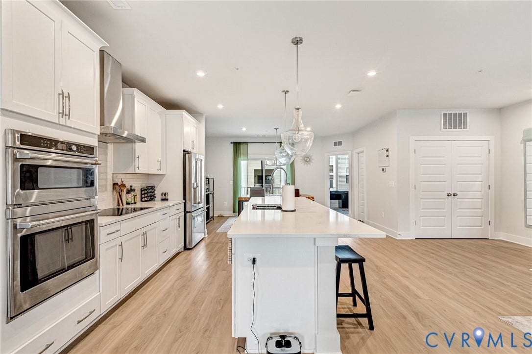 528 Greybull Walk, #B, Glen Allen, VA 23233 Gourmet kitchen with white cabinetry, stainless steel appliances, and a large central island