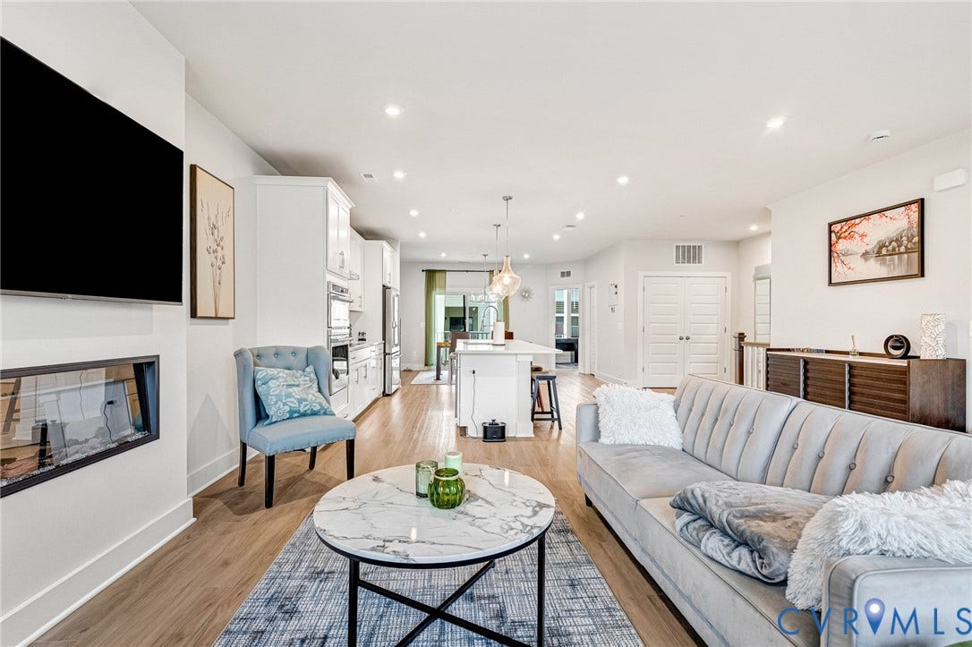 528 Greybull Walk, #B, Glen Allen, VA 23233 Open-concept living area featuring a linear fireplace, recessed lighting, wood-finish flooring, and a kitchen with white cabinetry