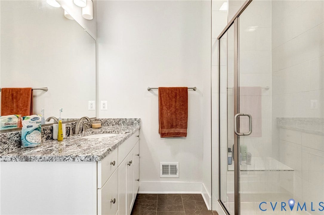 528 Greybull Walk, #B, Glen Allen, VA 23233 Double vanity with stone countertop, frameless glass shower enclosure, and built-in shower bench