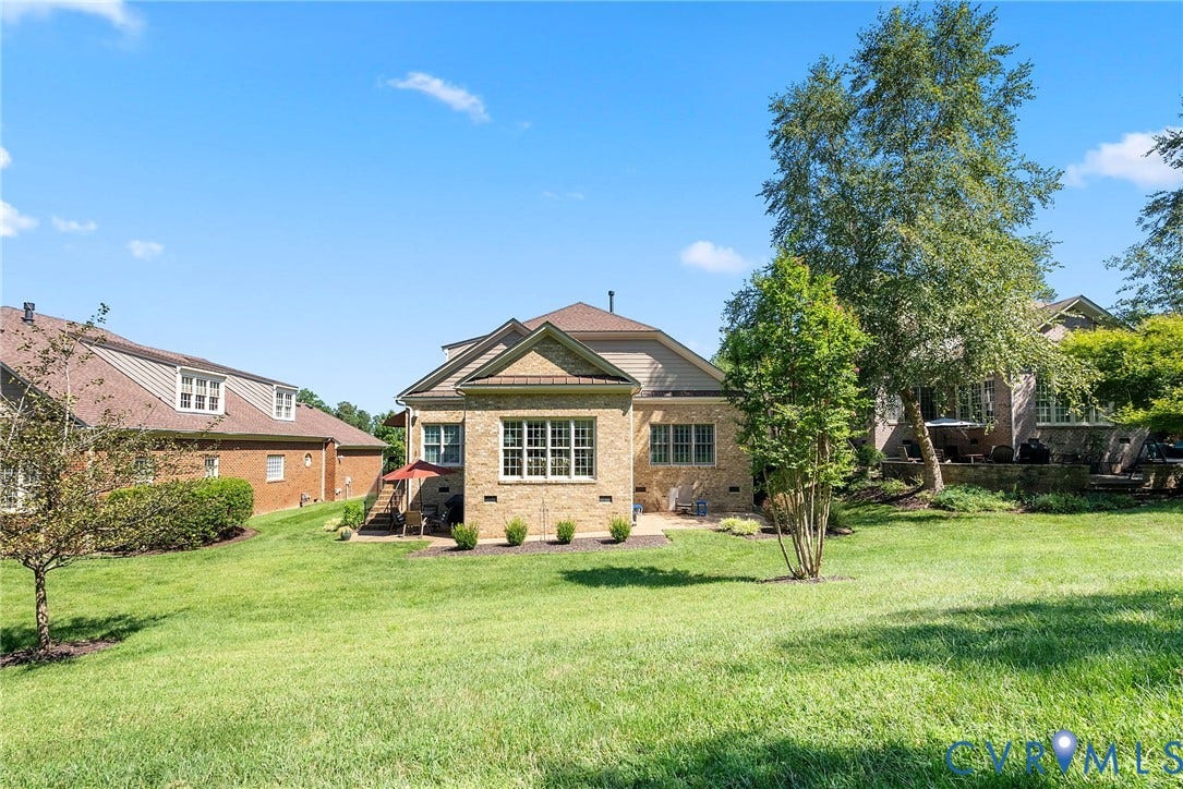 A lovely backyard setting with two patios providing options for outdoor dining, grilling, or simply enjoying the beautifully landscaped grounds.