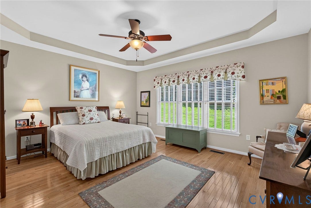 A spacious first-floor retreat with a tray ceiling, hardwood floors and abundant natural light. The bedroom flows seamlessly to two walk-in closets and ensuite bath.