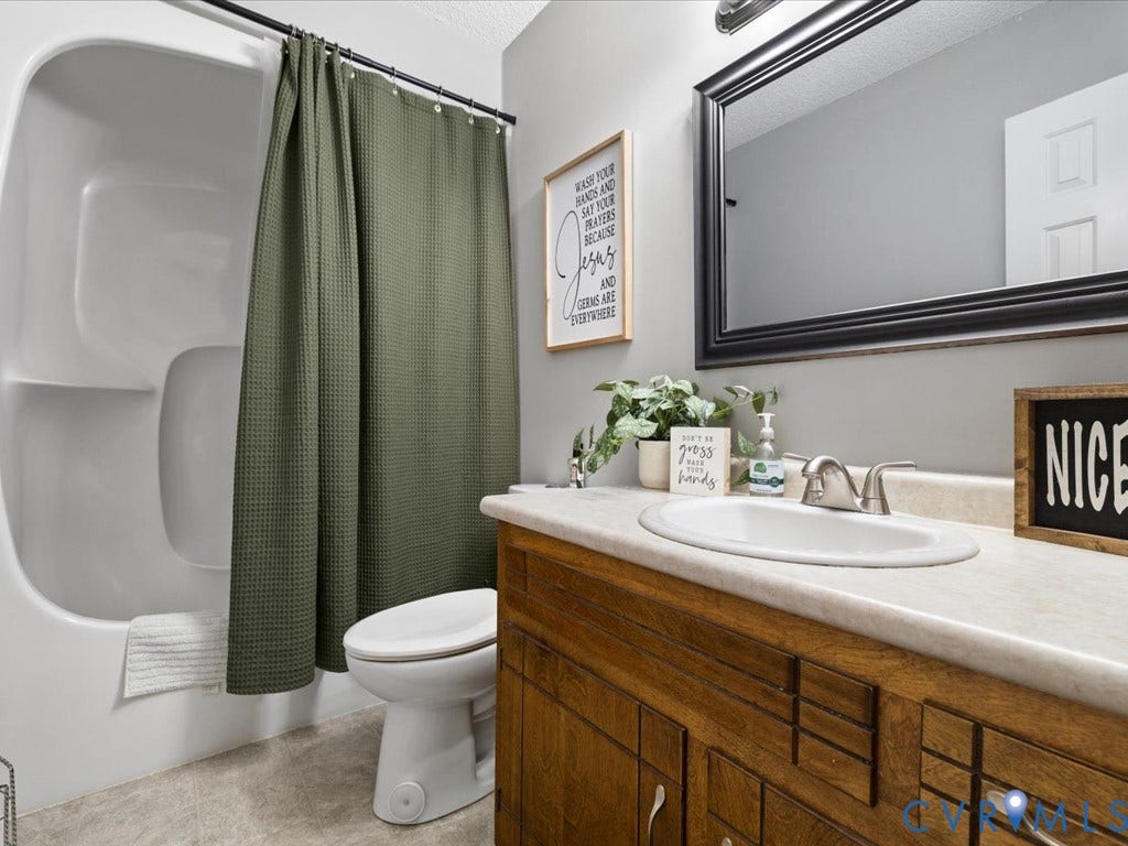 12724 S Chester Road, Chesterfield, VA 23831 Hall Bathroom with white bathtub/shower combination, and a wood vanity