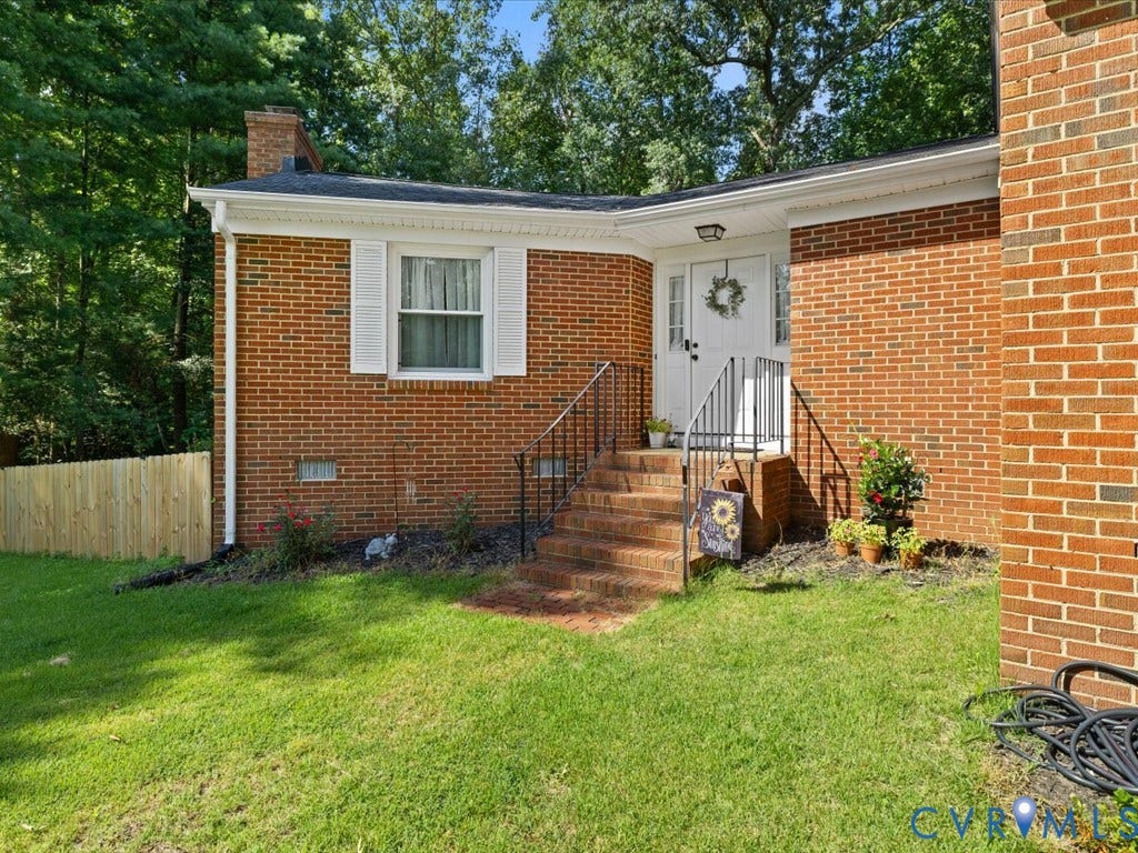 12724 S Chester Road, Chesterfield, VA 23831 Brick exterior, chimney, a newly installed wood fence, and a white entry door