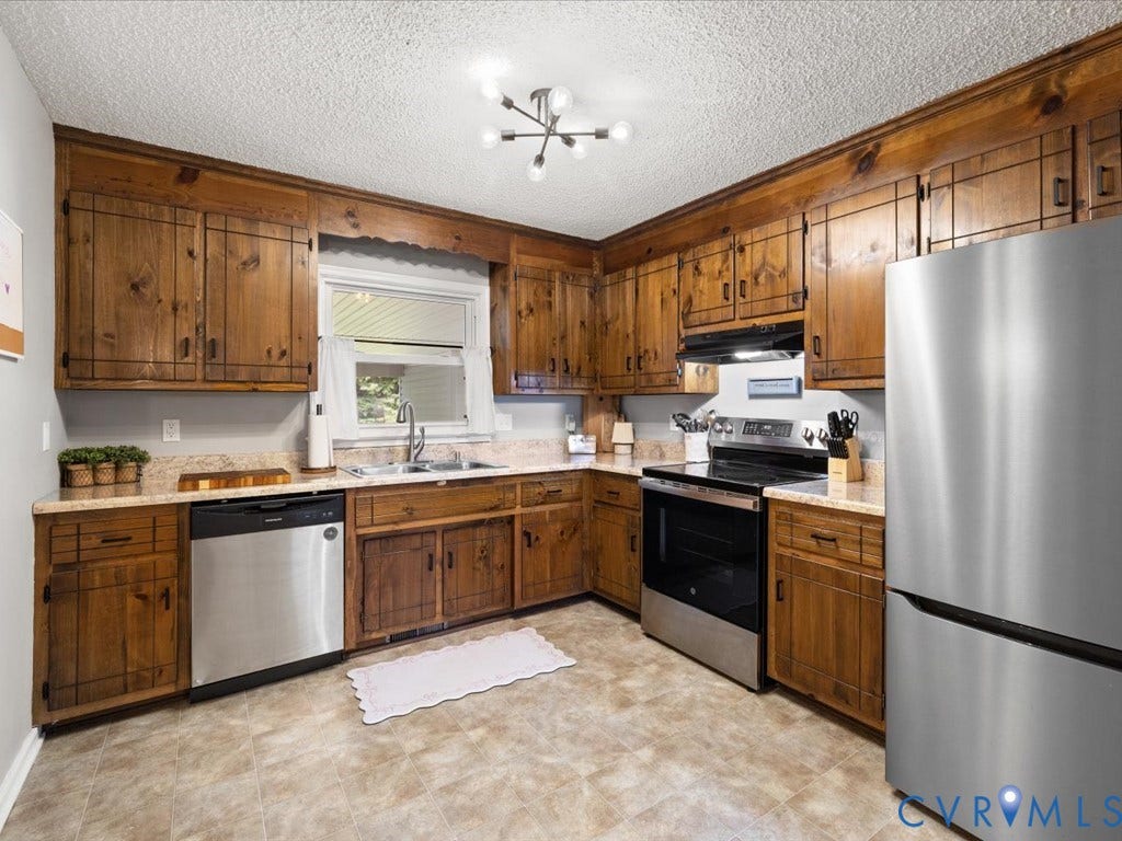 12724 S Chester Road, Chesterfield, VA 23831 Kitchen featuring wood-finish cabinetry, stainless steel appliances, and L-shaped countertops