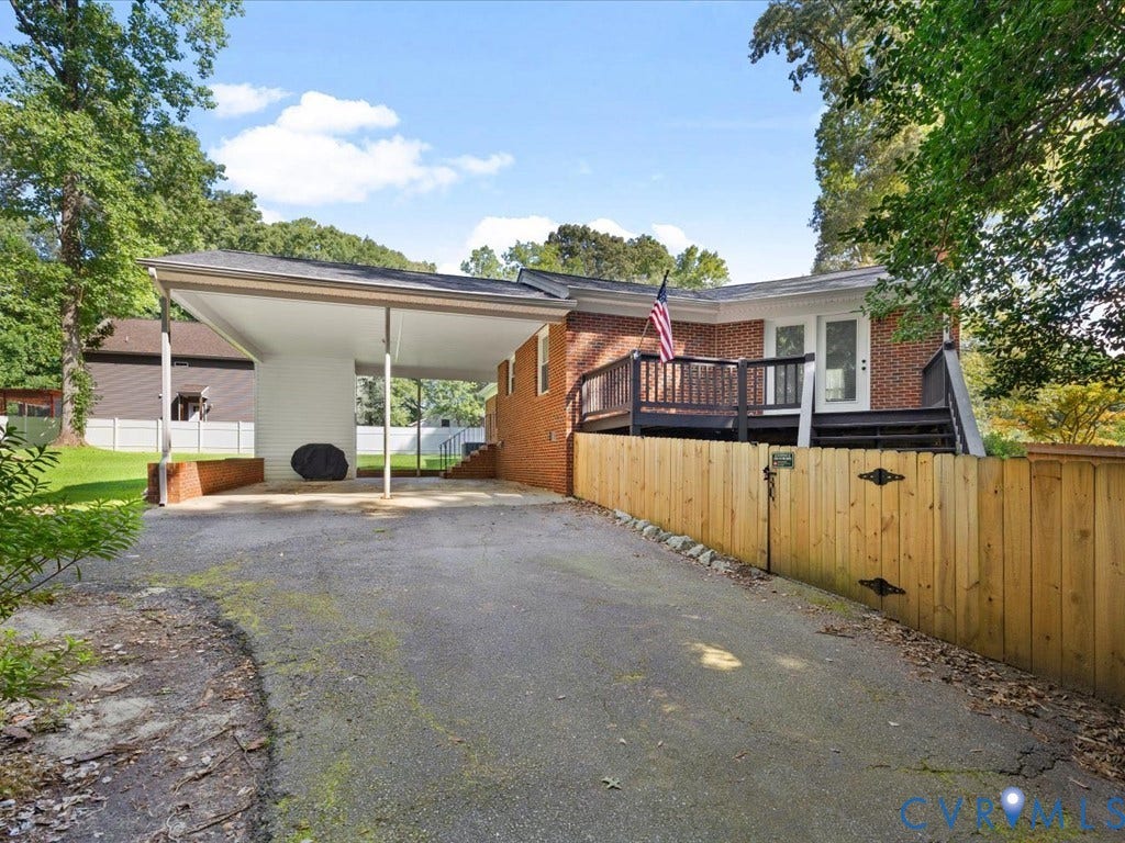 12724 S Chester Road, Chesterfield, VA 23831 Brick exterior residence featuring a covered carport, wood privacy fence, and an elevated deck with wood railing