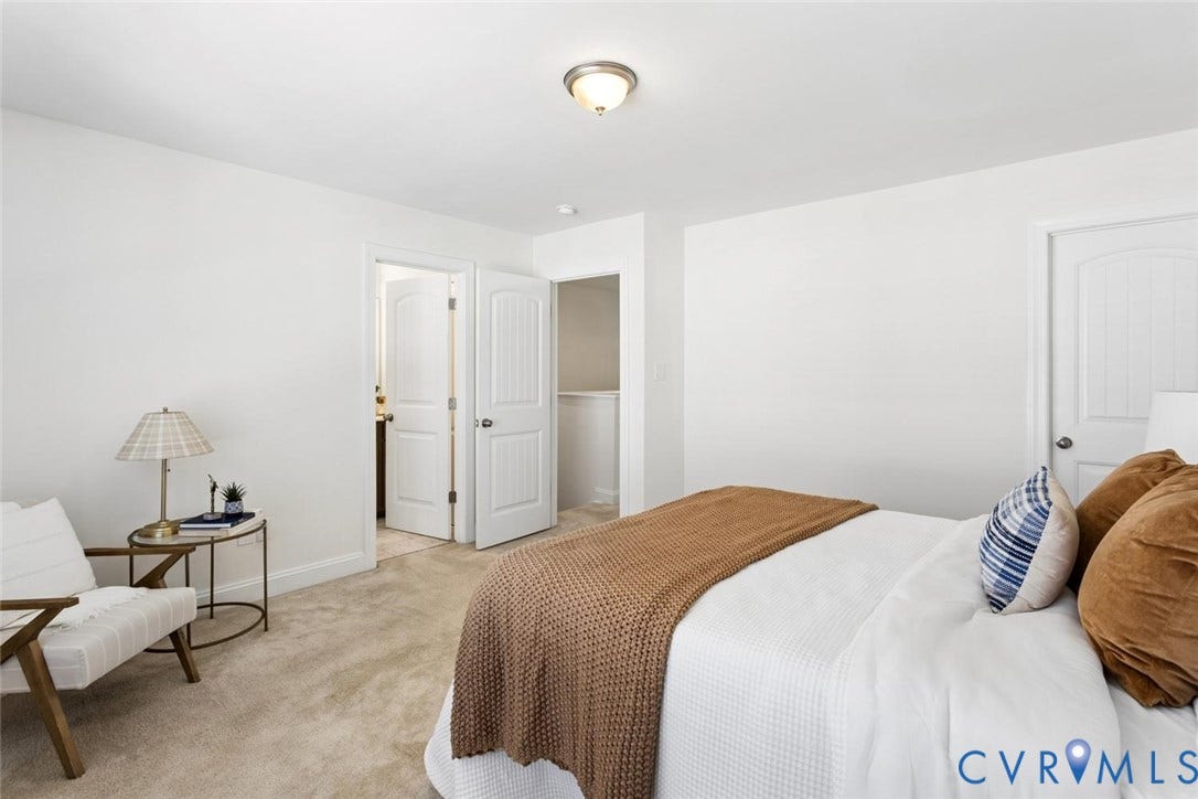 Plush carpet flooring, white walls, and a ceiling-mounted light fixture