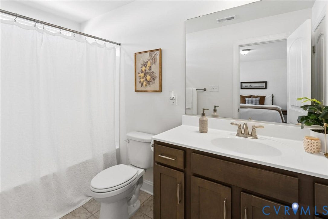 Ensuite bath featuring an oversized soaking tub perfect for relaxation, linen closet, natural light, and spacious vanity.
