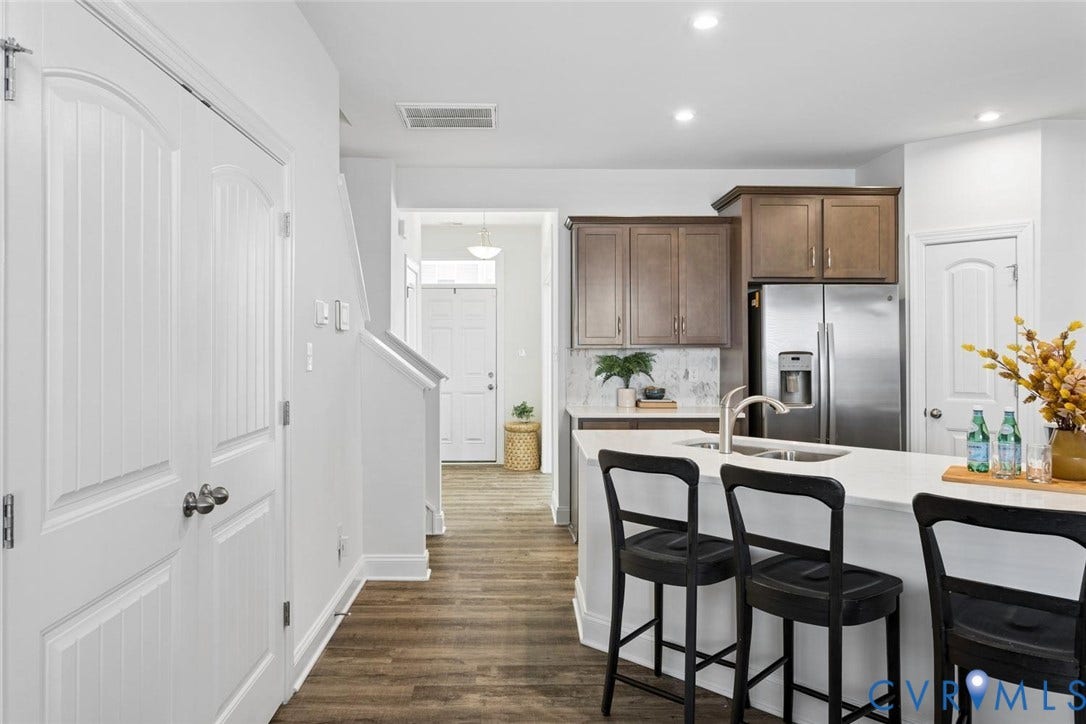 Kitchen with wood-finish flooring, white countertops, and stainless steel appliances