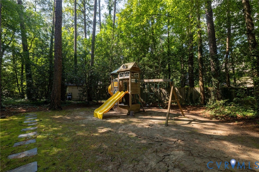 12800 Leffingwell Court, Henrico, VA 23233 Expansive backyard featuring mature trees, a stepping stone pathway, and a wooden fence boundary