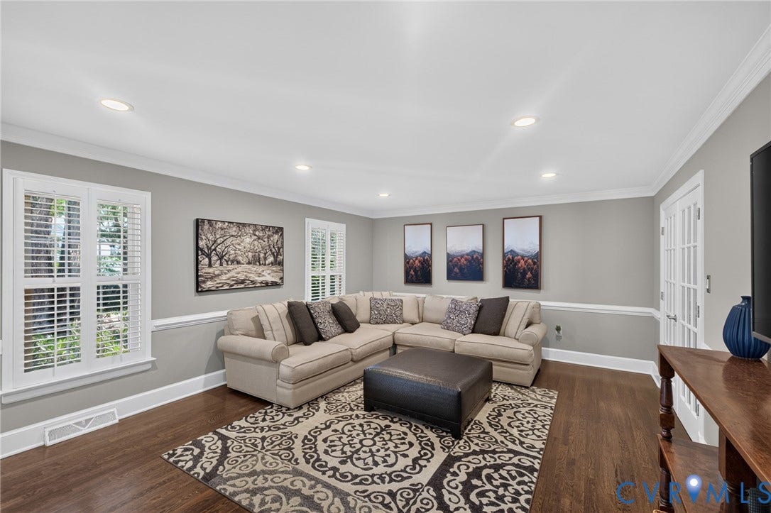 12800 Leffingwell Court, Henrico, VA 23233 Recessed lighting illuminates this living space featuring dark wood-finish flooring, white crown molding, and wainscoting