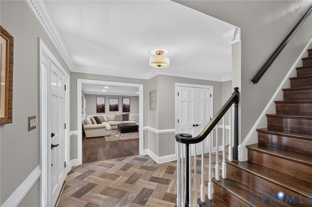 12800 Leffingwell Court, Henrico, VA 23233 Herringbone-patterned wood-finish flooring, dark wood staircase with white risers, black and white spindle railing, decorative crown molding, and a flush mount ceiling light