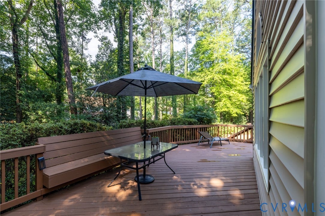 12800 Leffingwell Court, Henrico, VA 23233 Expansive wood deck with a built-in bench, wood railing, and surrounding mature trees