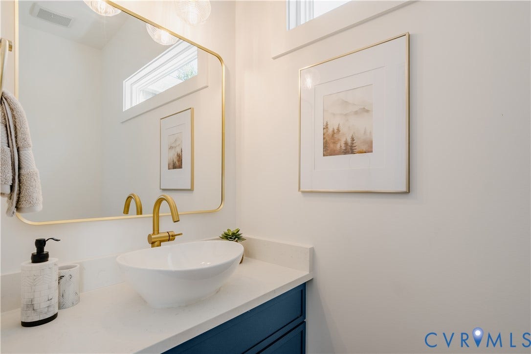 3106 Groveland Avenue, Richmond, VA 23222 Vessel sink with a gold-finish faucet, white countertop, blue cabinetry, and a gold-framed mirror