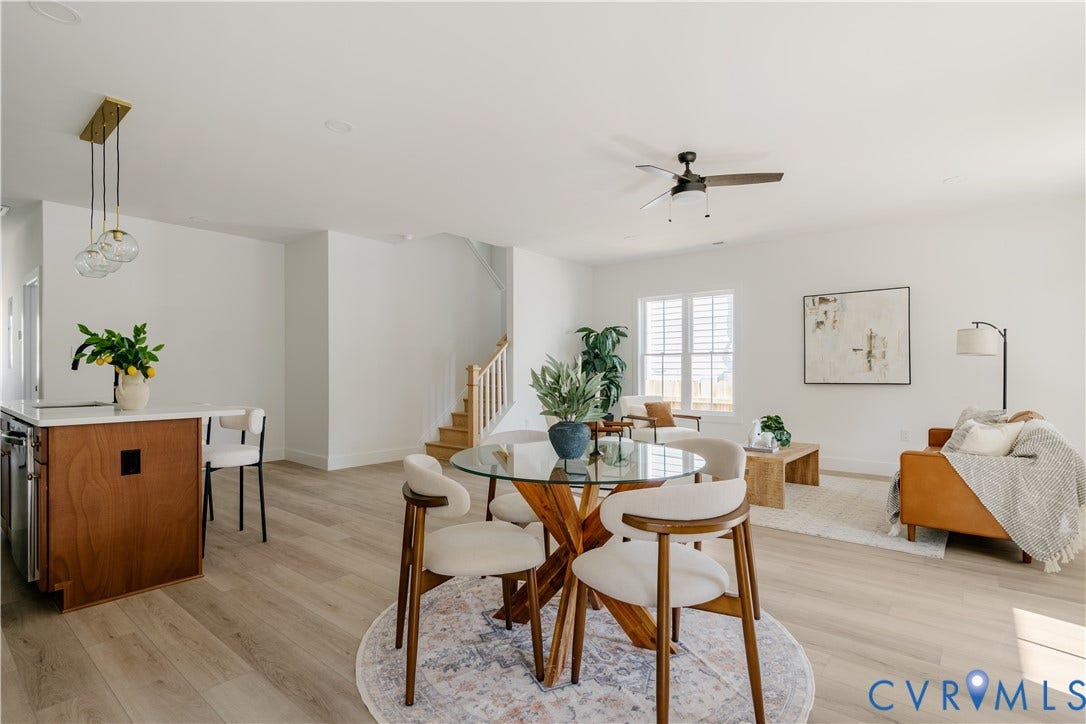 3106 Groveland Avenue, Richmond, VA 23222 Open-concept living space with light wood-finish flooring, a contemporary kitchen island featuring a light-toned countertop, a stylish brass pendant light fixture, and a ceiling fan