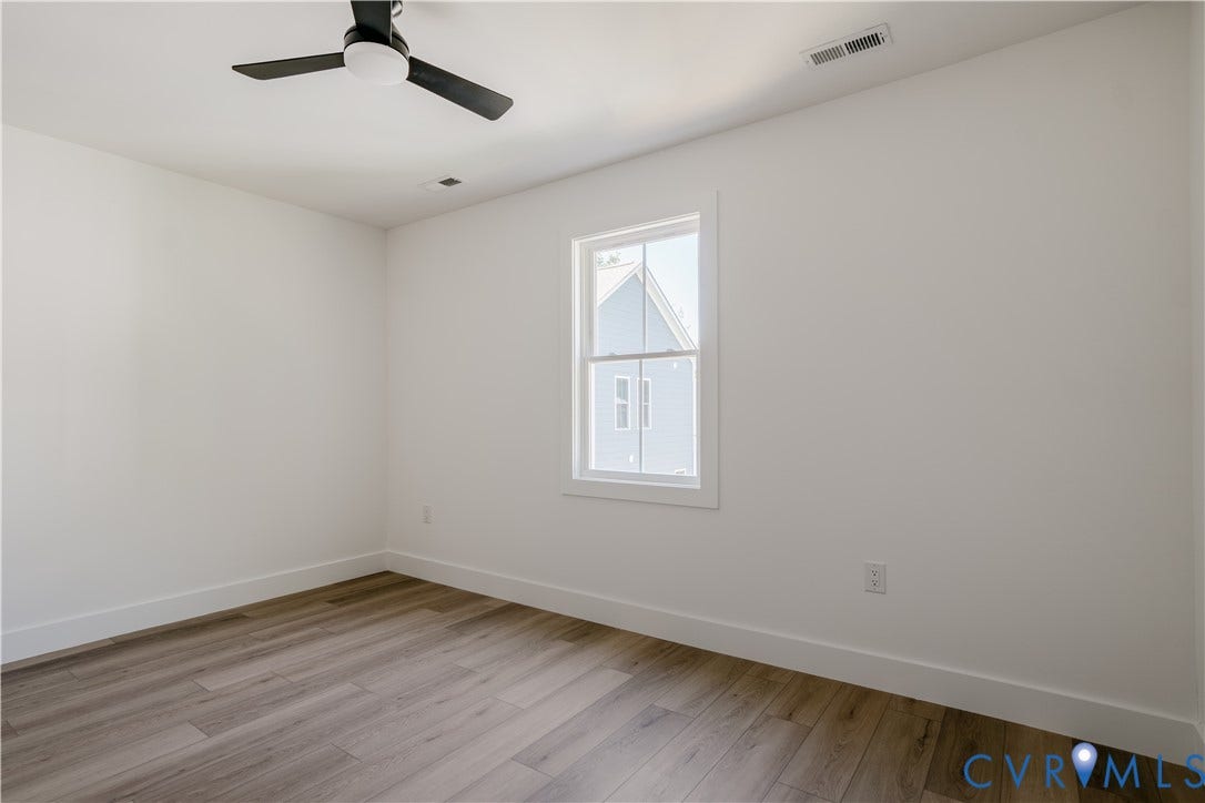 3106 Groveland Avenue, Richmond, VA 23222 Neutral wall paint, wood-finish flooring, white window trim, and a ceiling fan