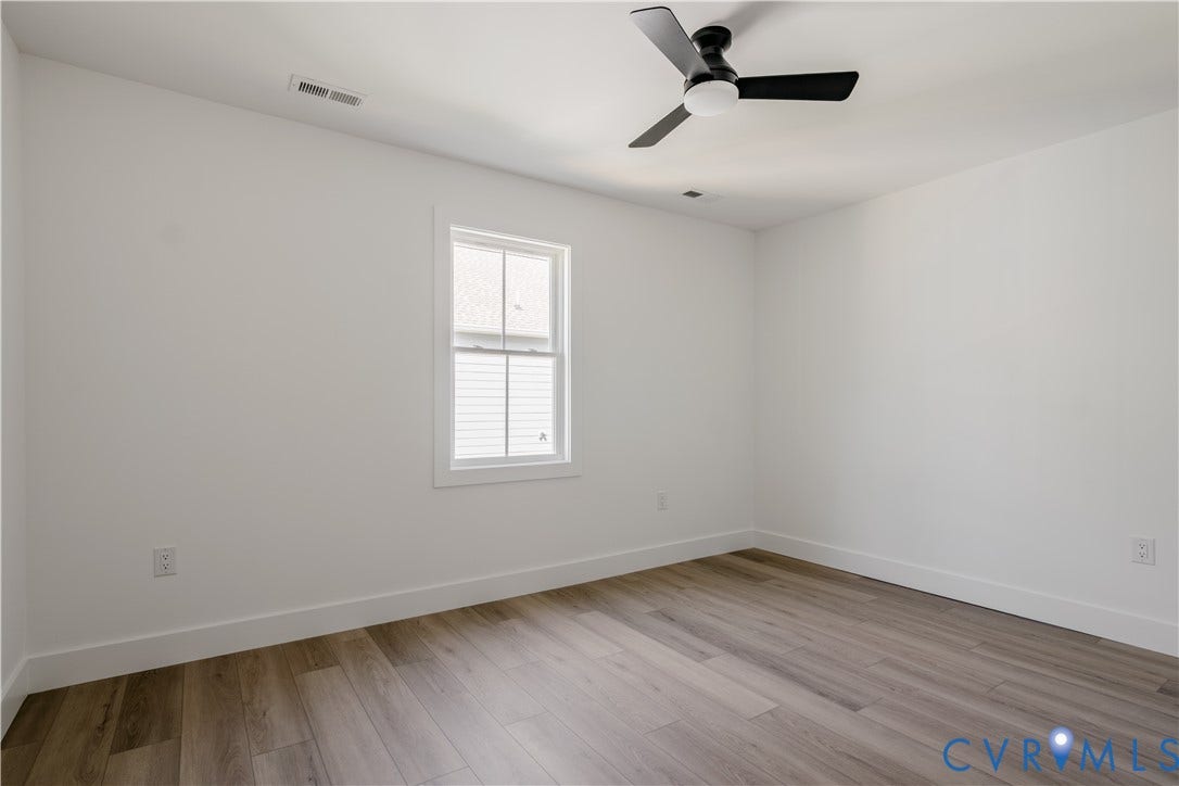 3106 Groveland Avenue, Richmond, VA 23222 Spacious room featuring wood-finish flooring, a contemporary ceiling fan with integrated lighting, and a double-hung window