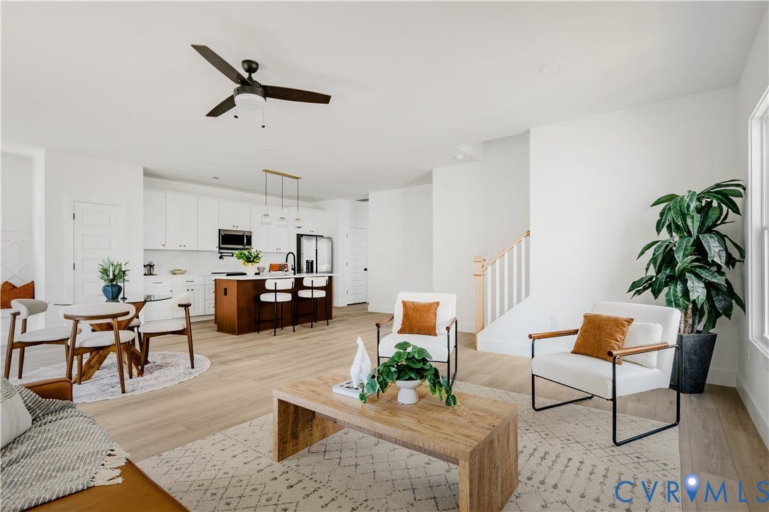 3106 Groveland Avenue, Richmond, VA 23222 Open-concept living space featuring wood-finish flooring, white walls, a modern ceiling fan, and a kitchen with white cabinetry and a wood-finish island