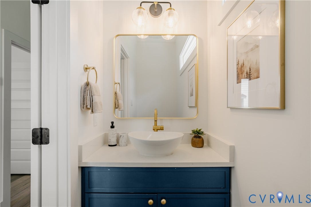 3106 Groveland Avenue, Richmond, VA 23222 Vanity featuring a white vessel sink, gold-toned faucet, and a wall-mounted mirror