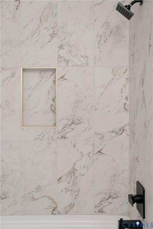 3106 Groveland Avenue, Richmond, VA 23222 Bathtub with a built-in niche, featuring tile with marble-effect veining, matte black shower head, and matte black bath fixtures
