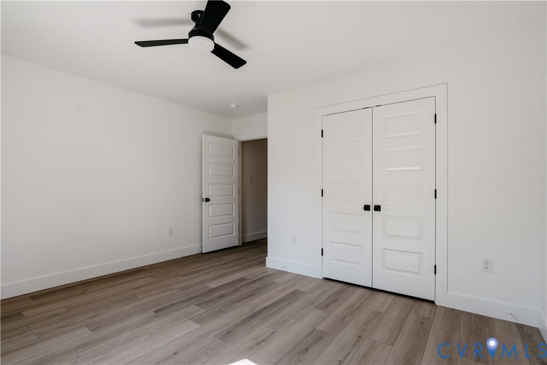 3106 Groveland Avenue, Richmond, VA 23222 Light wood-finish flooring, white walls, black ceiling fan, and paneled doors