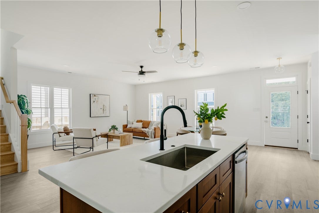 3106 Groveland Avenue, Richmond, VA 23222 Kitchen island with an undermount sink and a matte black faucet, integrated dishwasher, and wood-finish cabinetry