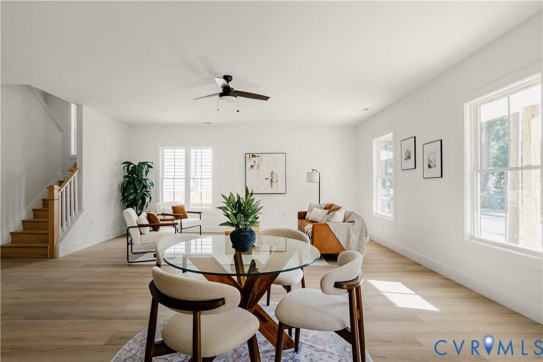 3106 Groveland Avenue, Richmond, VA 23222 Open-concept living area featuring light wood-finish flooring, white walls, multiple windows, and a staircase with wood treads and white risers