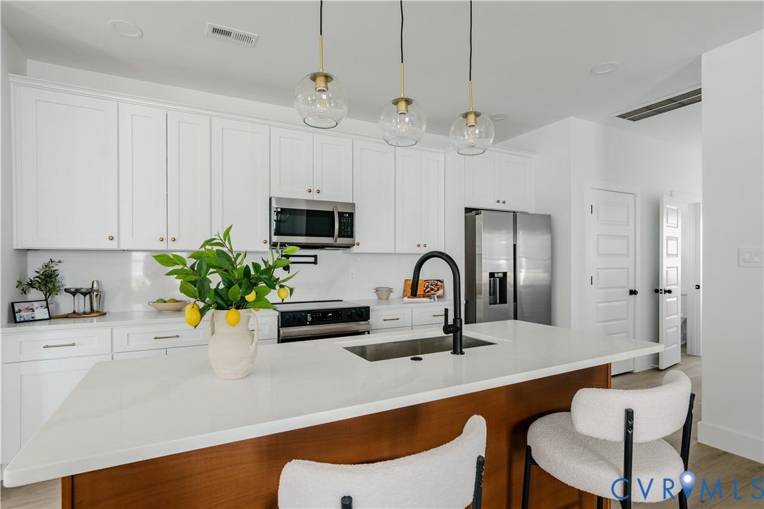 3106 Groveland Avenue, Richmond, VA 23222 White cabinetry with gold-tone hardware, stainless steel appliances, and a central island with a wood-finish base